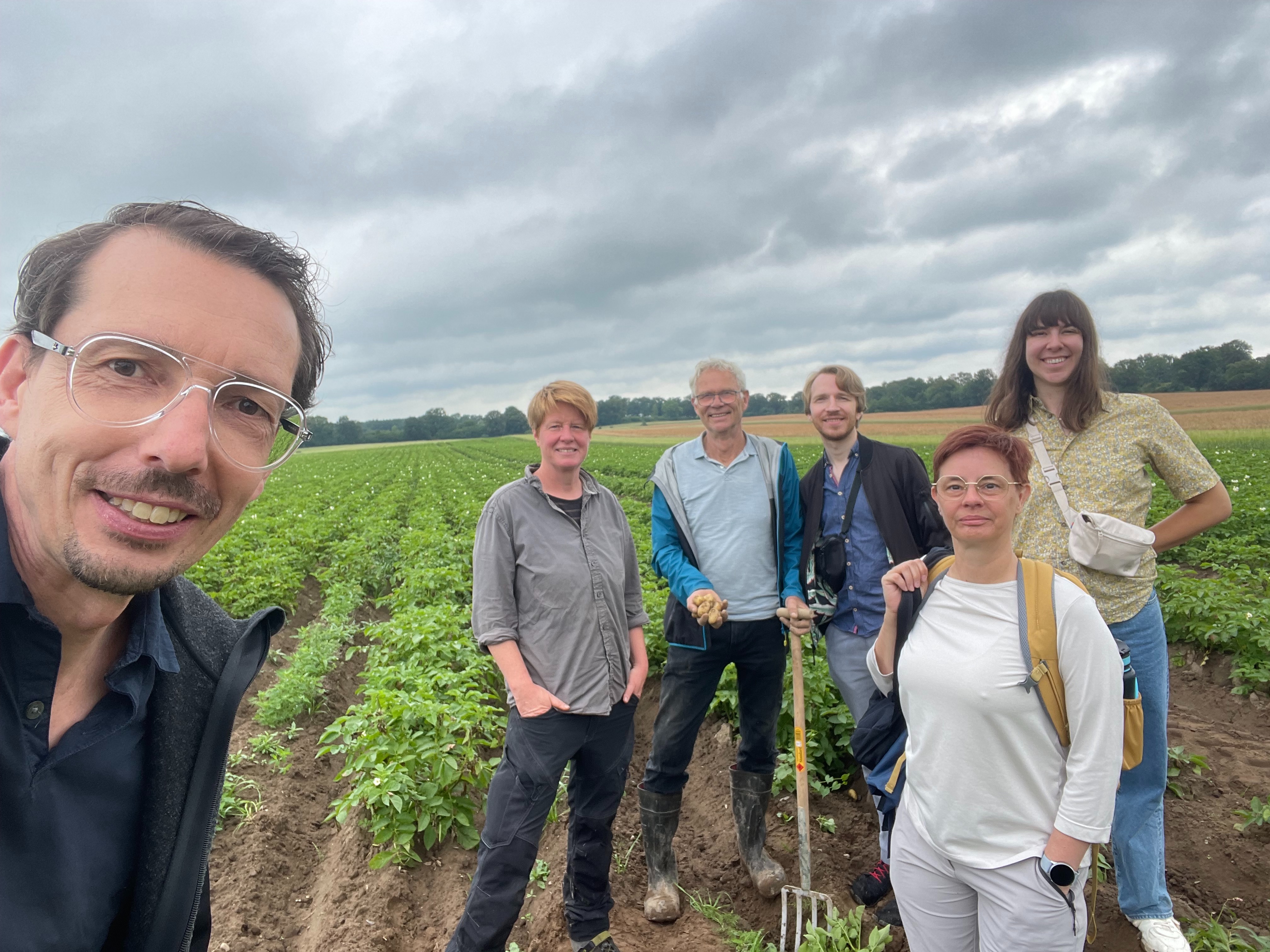 Gründer Nicolas Barthelme und Verbraucher und Team stehen auf Kartoffelacker, machen sich Bild von der schlechten Ernte,